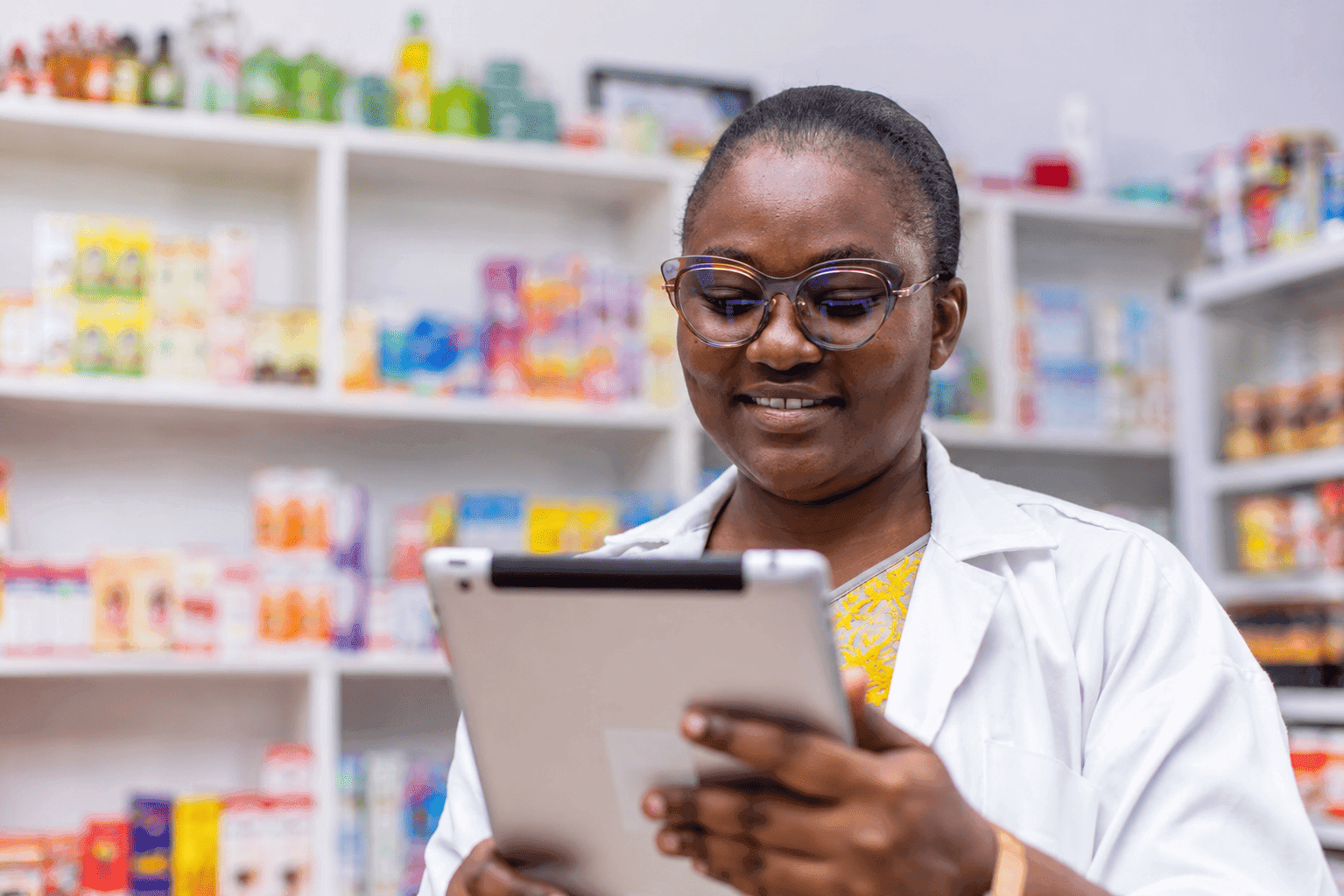 Facilitator registering patient at pharmacy counter with tablet